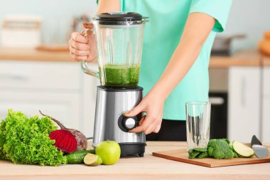 Mutfakta sağlıklı meyve suyu hazırlayan bir kadın.