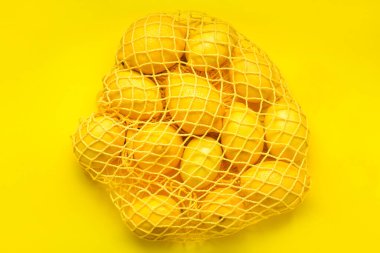 Renkli arkaplanda olgun limonlu ağ torbası