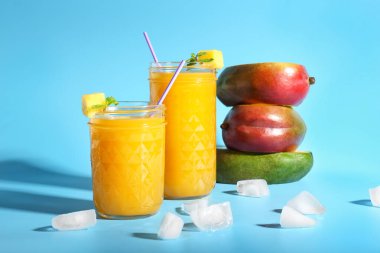 Renkli arkaplanda lezzetli mango suyu kavanozları