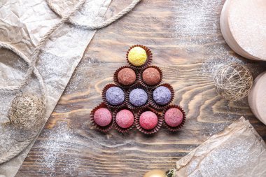 Ahşap zemin üzerinde lezzetli şekerlerden yapılmış Noel ağacı şekli