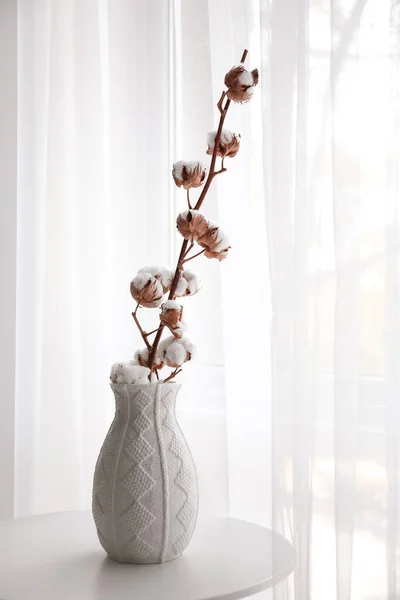 Ваза с красивыми цветами хлопка на столе у окна — стоковое фото