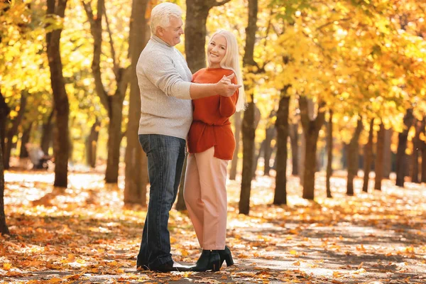 Loving mature couple dancing in autumn park — Stock Photo, Image