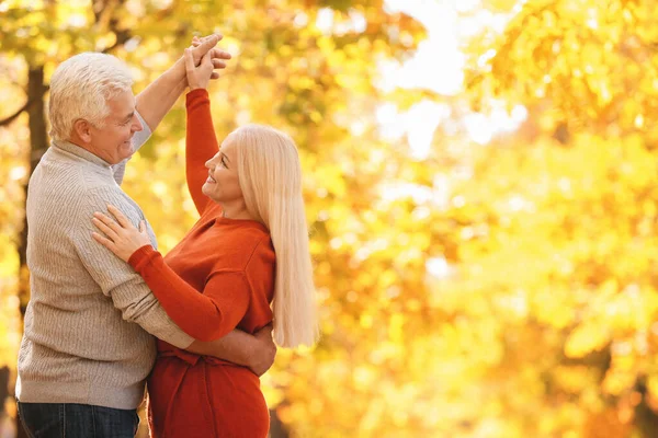 Loving mature couple dancing in autumn park — Stock Photo, Image