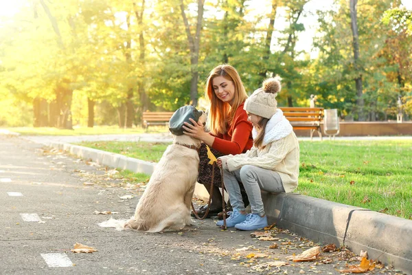 Mother with little daughter and funny dog in autumn park — Stock Photo, Image