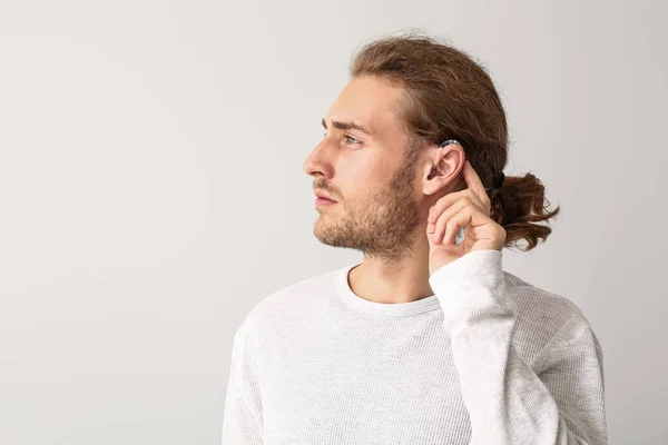 Young man with hearing aid on white background — Stock Photo, Image