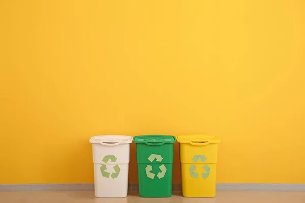 Containers voor afval in de buurt van kleur muur. Recyclingconcept — Stockfoto