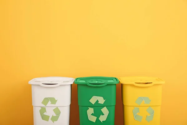 Pojemniki na śmieci w pobliżu kolorowych ścian. Koncepcja recyklingu — Zdjęcie stockowe