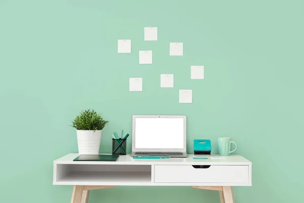 Local de trabalho confortável com laptop moderno perto da parede de cor — Fotografia de Stock