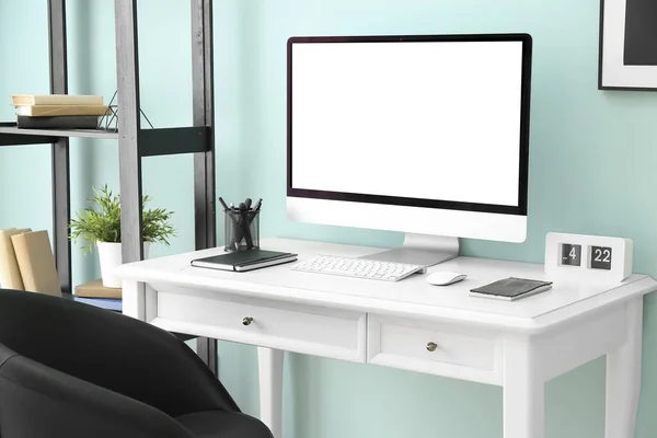 Lieu de travail confortable avec ordinateur moderne près du mur de couleur — Photo