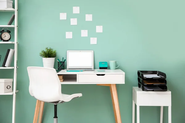 Άνετο χώρο εργασίας με σύγχρονο φορητό υπολογιστή κοντά στο χρώμα τοίχο — Φωτογραφία Αρχείου