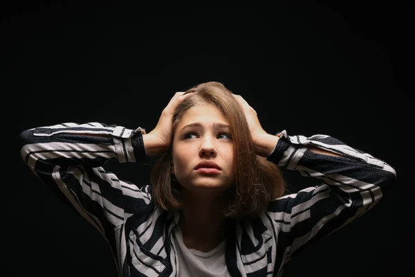 Trauriges Teenager-Mädchen auf dunklem Hintergrund — Stockfoto