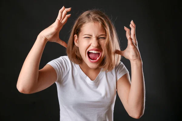 Screaming teenage girl on dark background — Stock Photo, Image
