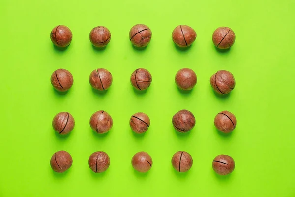 Sabrosas nueces de macadamia sobre fondo de color — Foto de Stock