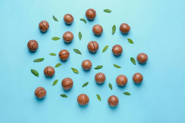 Smakelijke macadamia noten op kleur achtergrond — Stockfoto