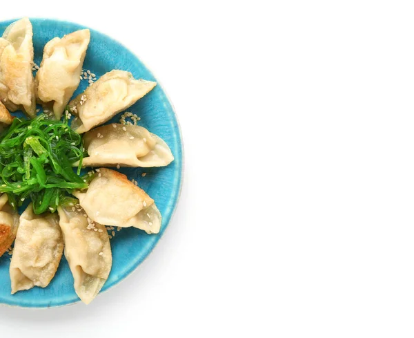 Plaat met smakelijke Japanse gyoza op witte achtergrond — Stockfoto