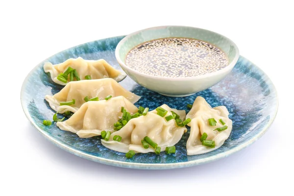 Placa con sabrosa gyoza japonesa y salsa sobre fondo blanco — Foto de Stock