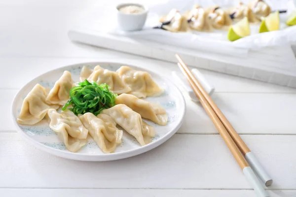 Plate with tasty Japanese gyoza on white table — Stock Photo, Image