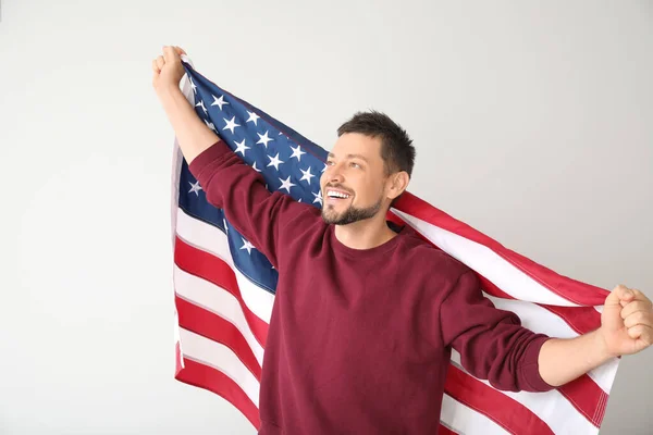 Handsome man with USA flag on light background. Memorial Day celebration — Stock Photo, Image