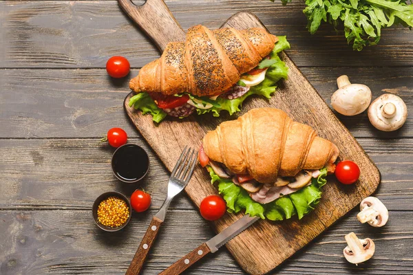Bord met lekkere croissant broodjes op houten tafel — Stockfoto