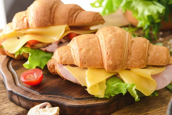 Смачні бутерброди круасанів на дерев'яній дошці — стокове фото