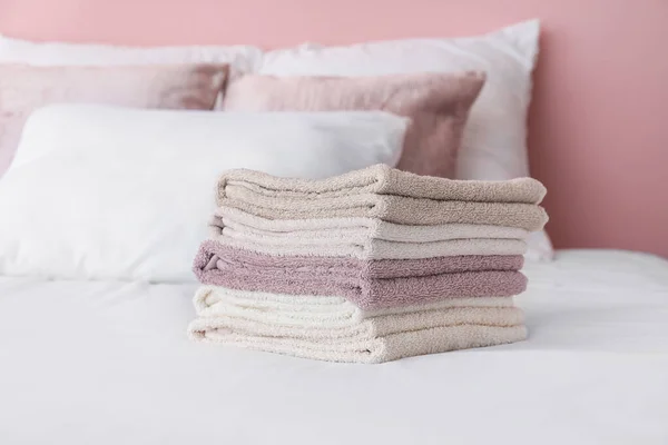 Stack med mjuka rena handdukar på sängen — Stockfoto