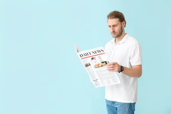 Retrato de hombre guapo con periódico sobre fondo de color — Foto de Stock