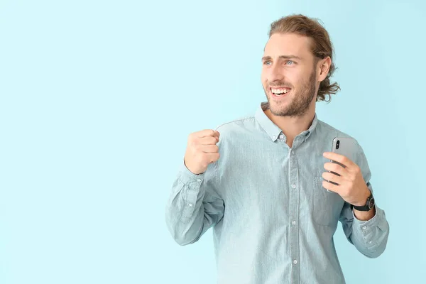 Portrait of happy man with mobile phone on color background — Stock Photo, Image