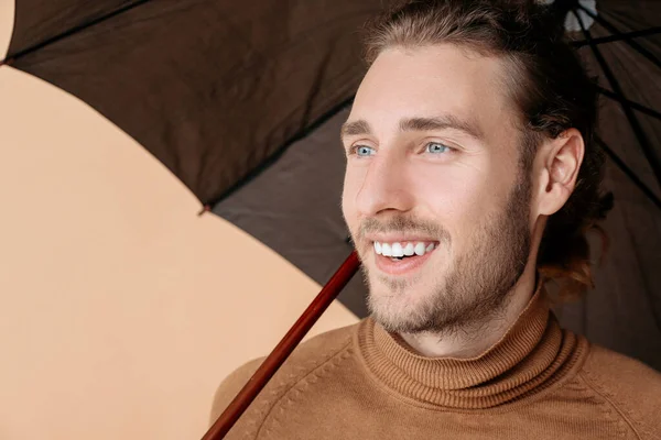 Portrait of handsome man with umbrella on color background — Stock Photo, Image