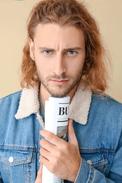 Retrato de hombre guapo con periódico sobre fondo de color — Foto de Stock