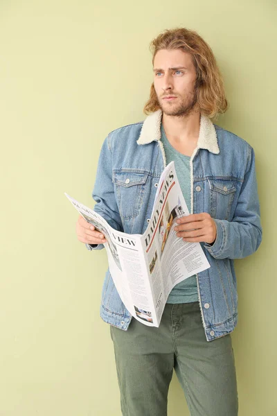 Portré jóképű férfi újsággal színes háttér — Stock Fotó