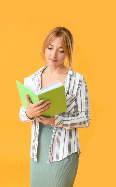 Κομψή ώριμη γυναίκα με βιβλίο στο φόντο χρώμα — Φωτογραφία Αρχείου