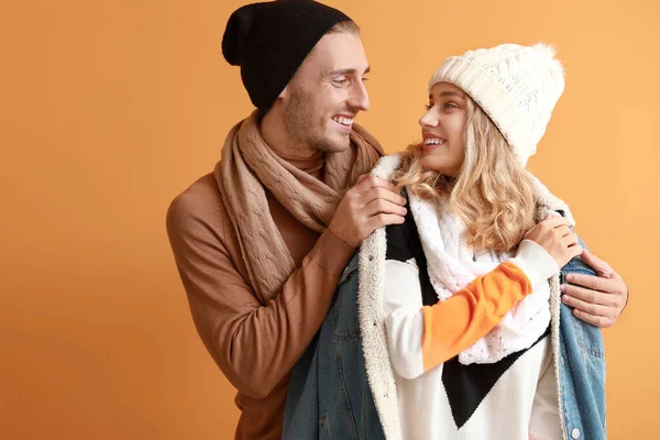 Щаслива молода пара в теплому осінньому одязі на кольоровому фоні — стокове фото
