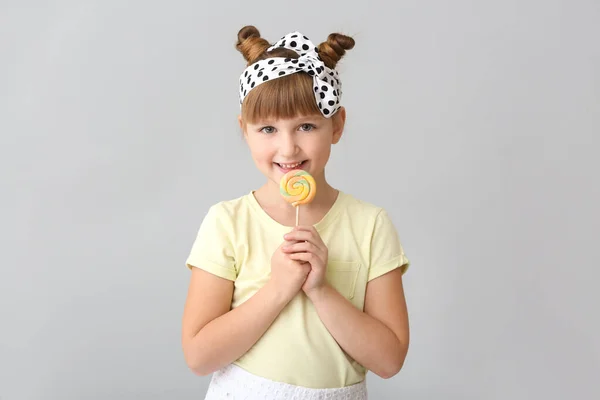 Cute little girl with lollipop on light background — Stock Photo, Image