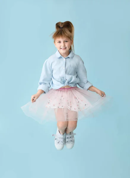 Renkli arka planda zıplayan küçük kız — Stok fotoğraf