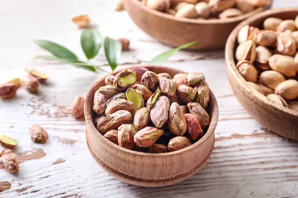 Bowls with tasty pistachio nuts on table — Stock Photo, Image