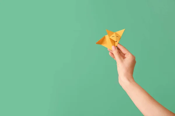 Mano femenina con origami zorro sobre fondo de color — Foto de Stock