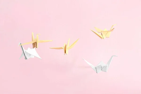 Origami cranes on color background — Stock Photo, Image