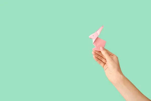 Female hand with origami rabbit on color background — Stock Photo, Image