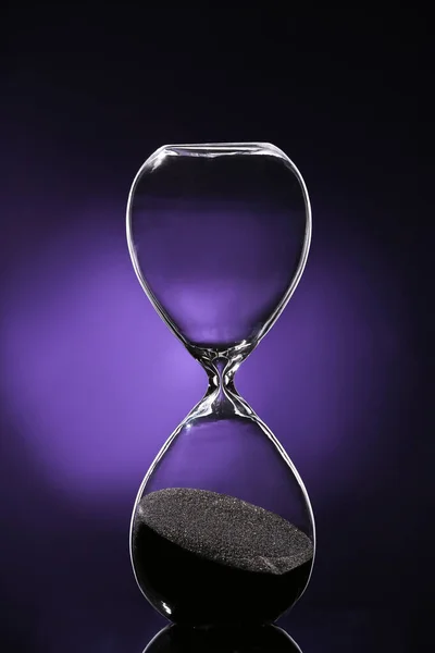 Кришталевий пісочний годинник на фоні темного кольору — стокове фото