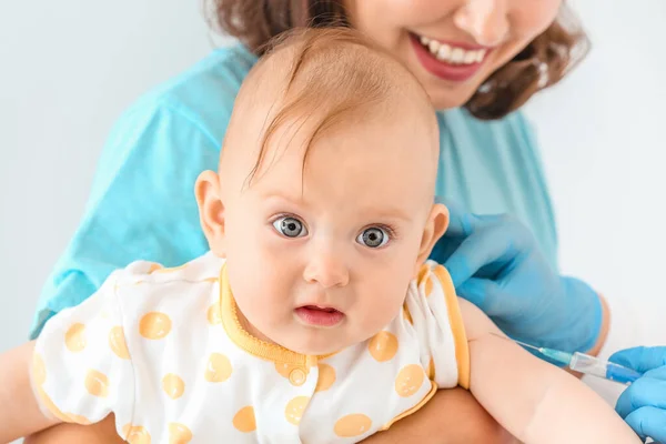 Pediatra vacunando al pequeño bebé sobre fondo claro —  Fotos de Stock