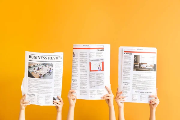 Female hands with newspapers on color background — Stock Photo, Image