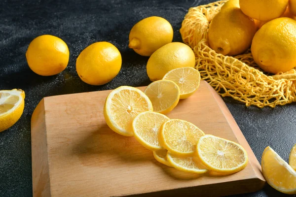 Planche à découper et citrons mûrs sur table — Photo