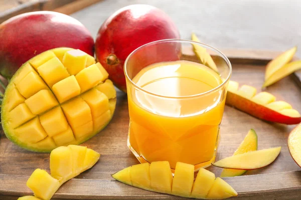 Lekkere mango en glas sap op tafel — Stockfoto