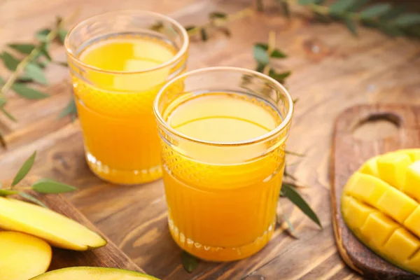 Glazen van smakelijke mango sap op tafel — Stockfoto