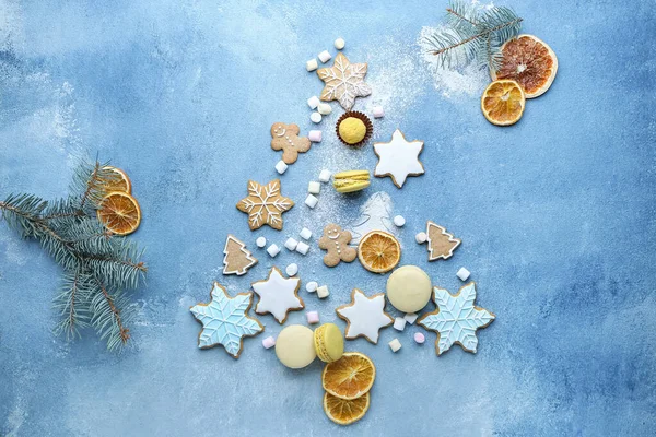 Christmas tree shape made of tasty treats on color background — Stock Photo, Image