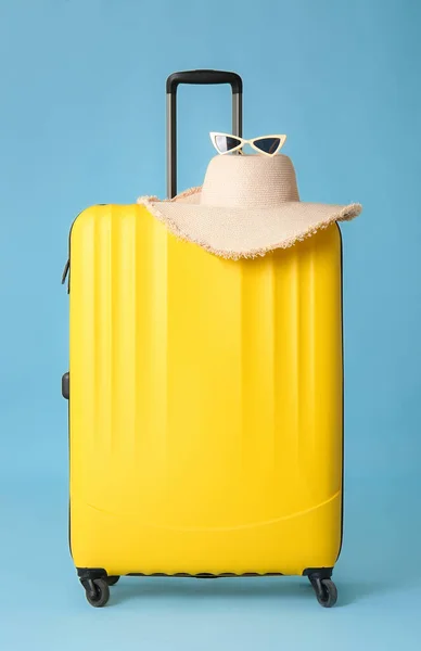 Maleta embalada, sombrero y gafas sobre fondo de color. Concepto de viaje — Foto de Stock