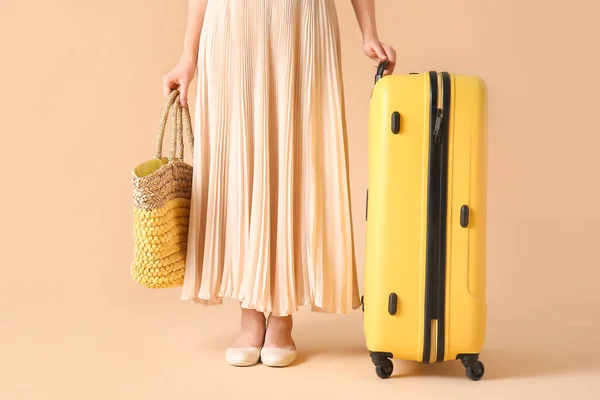 Frau mit Strandtasche und Koffer auf farbigem Hintergrund. Reisekonzept — Stockfoto