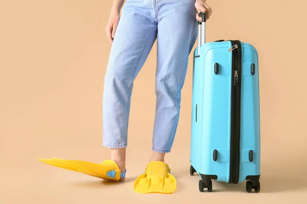 Mujer en paletas y con maleta sobre fondo de color. Concepto de viaje — Foto de Stock