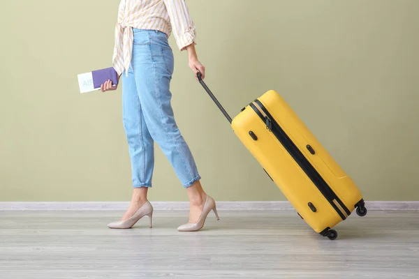 Mujer con maleta y documentos contra pared de color. Concepto de viaje — Foto de Stock