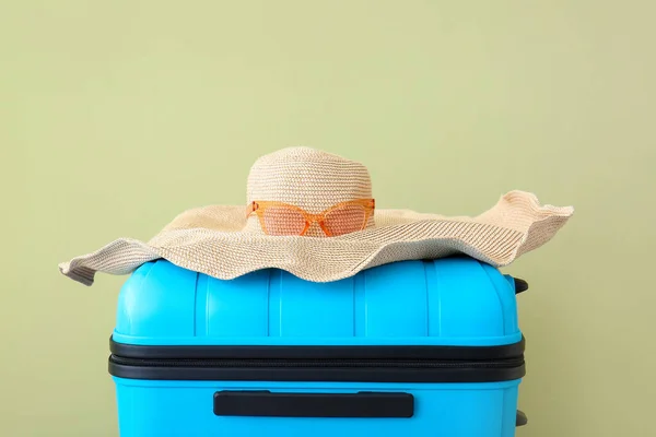 Maleta y sombrero embalados sobre fondo de color. Concepto de viaje — Foto de Stock